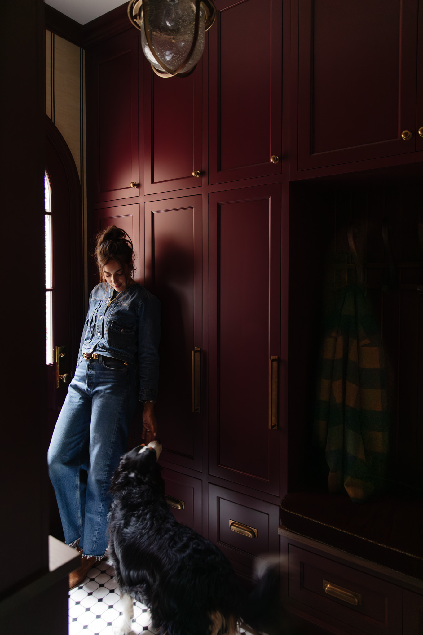 Julia in the mudroom looking at Cricket the pup