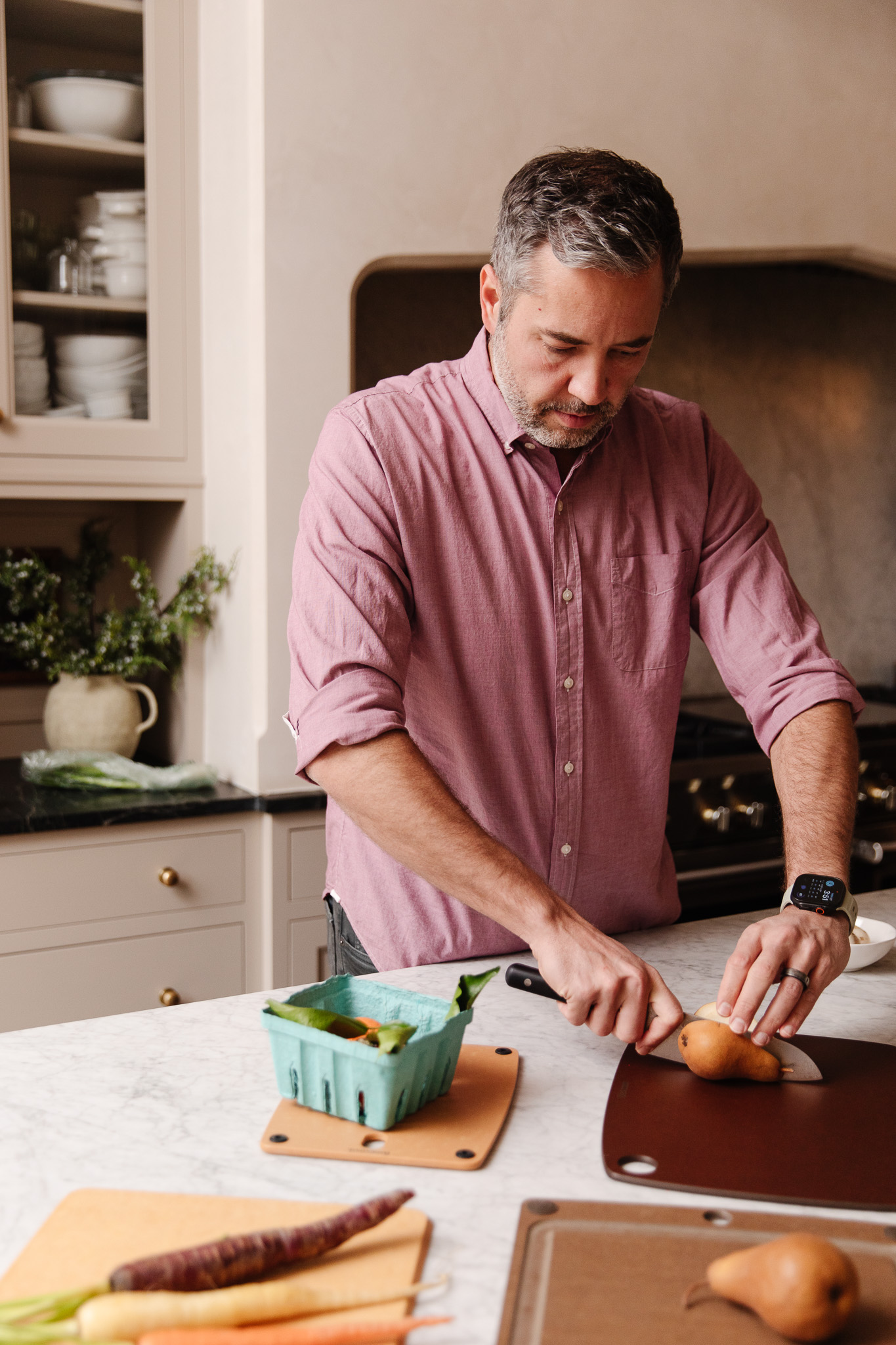 Chris slicing a brown pear on a dark brown cutting board