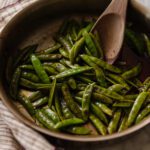 Blistered sugar snap peas with honey in a saute pan