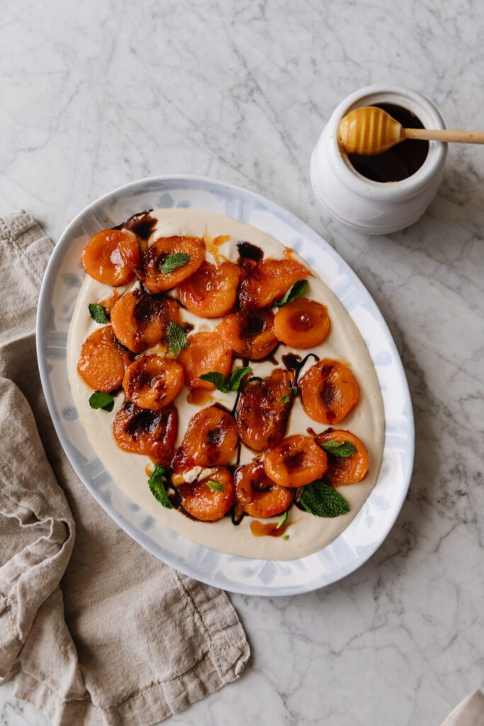A serving platter of caramelized apricots over a whipped ricotta cream
