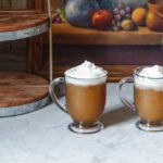 Butterbeer slushies in glass mugs topped with whipped cream