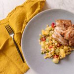 Salt & vinegar chicken thighs next to a grilled corn salad