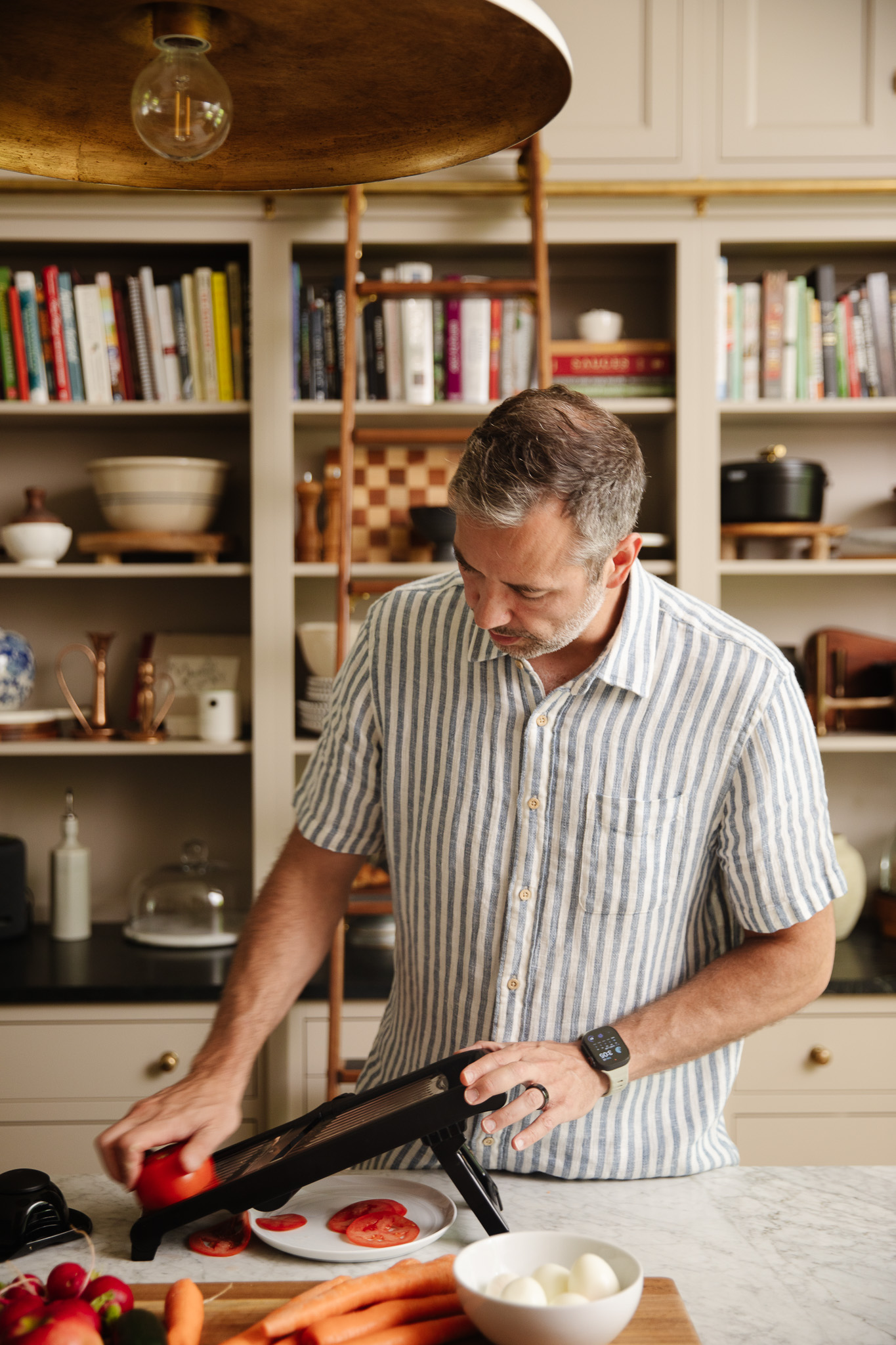 Chris slicing vegetables on a mandoline slicer