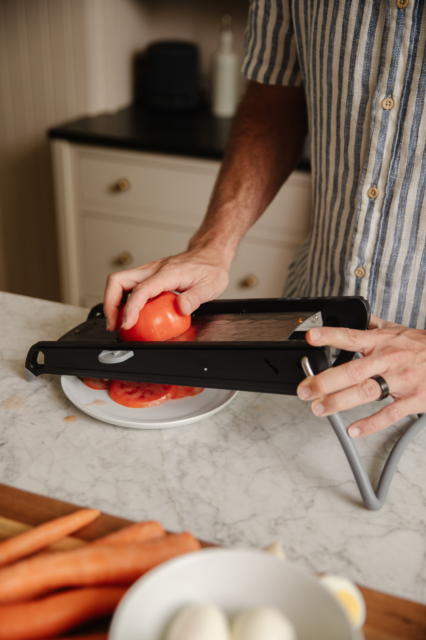 Chris slicing a tomato on a microplane slicer