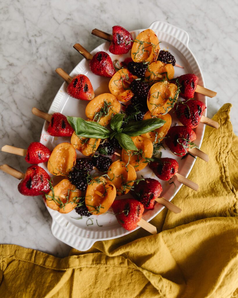 A platter of grilled fruit skewer kebabs