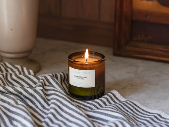 Tomato candle lit on a marble countertop