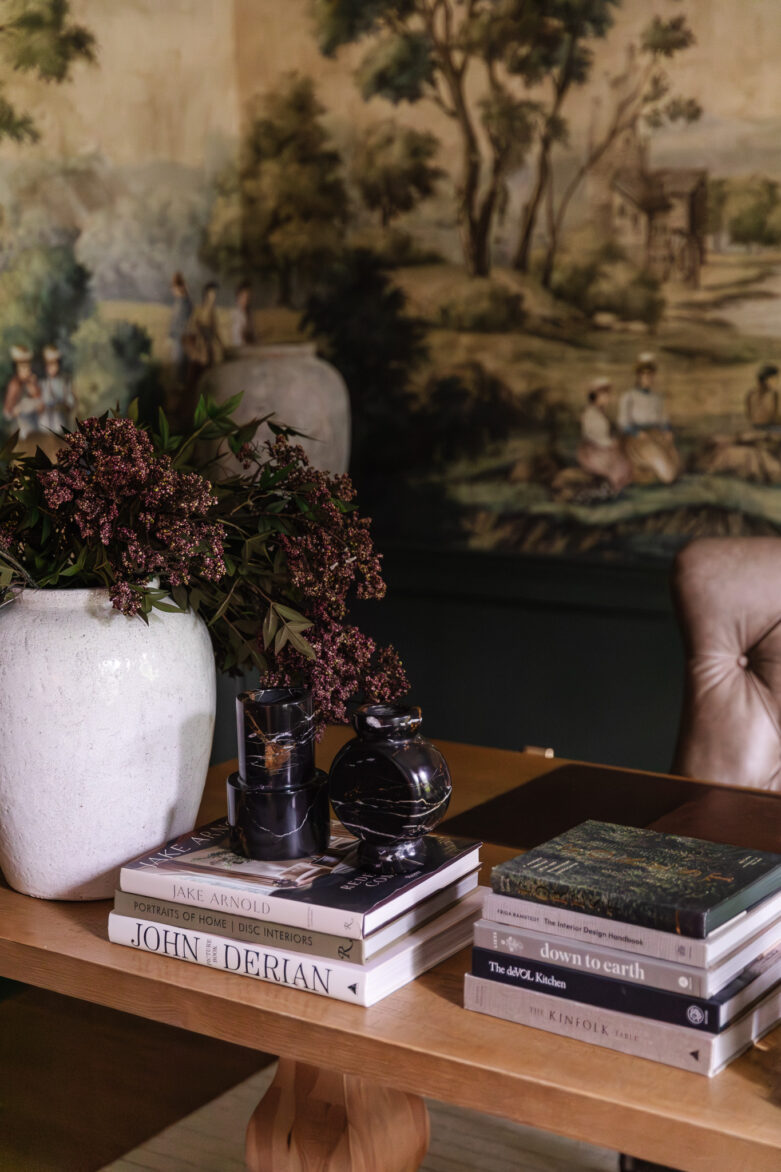 Study desk with coffee table books and dark marble vases