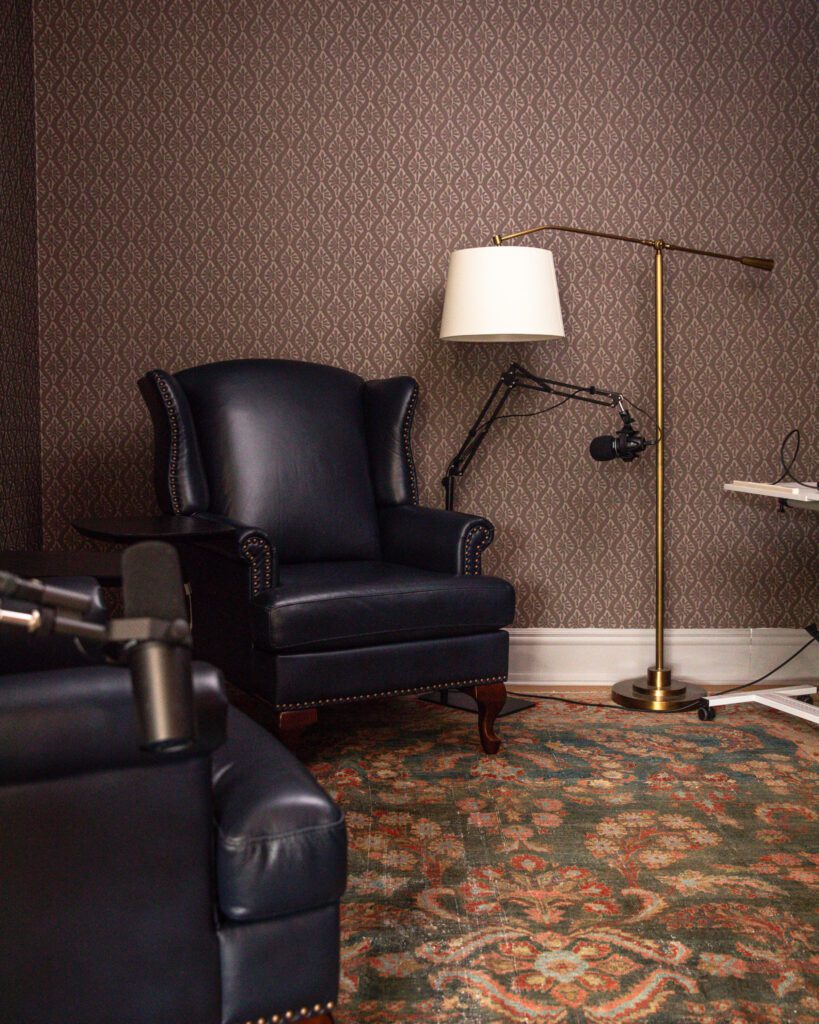 Chris Loves Julia podcast room with three wingback chairs, floor lamps, and a rug