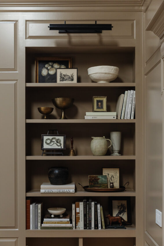 Built-in bookshelves in the updated living room styled with coffee table books, vases, and small art