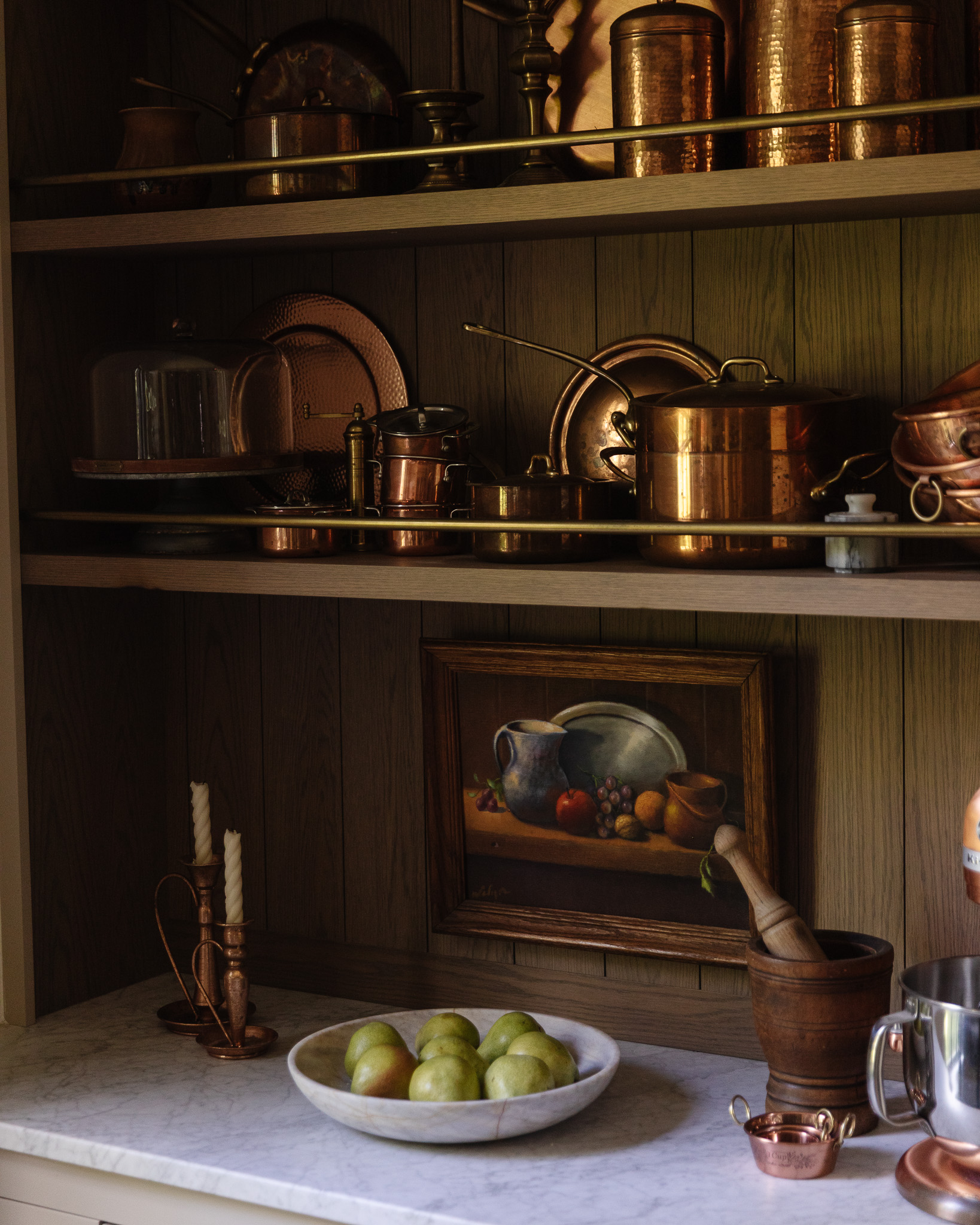 Fruit art hung on the wall of kitchen shelves