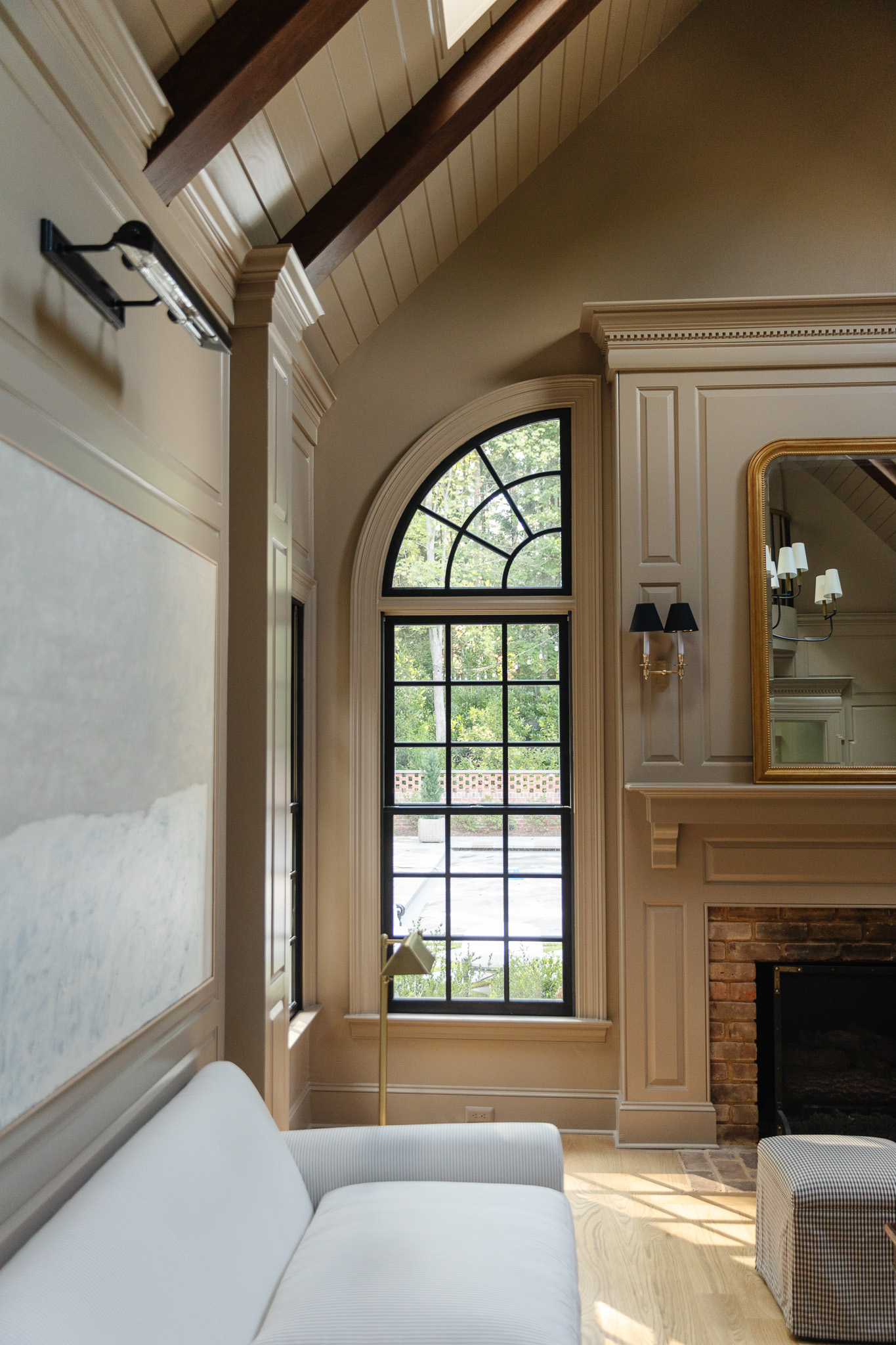 Black windows around a mantle in a living room painted in London Stone by Farrow & Ball