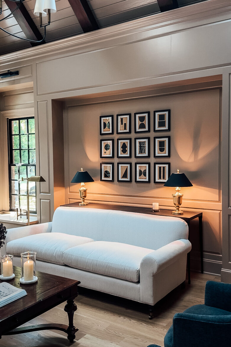 A gallery wall of original shape art by Josh Young above a white sofa