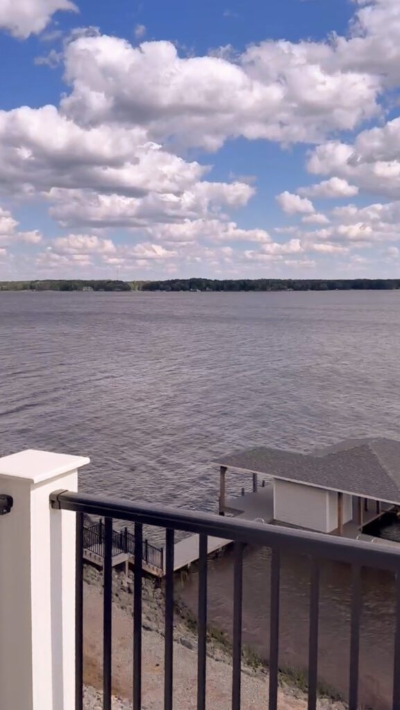 A view of a lake and a bright blue sky from a back porch