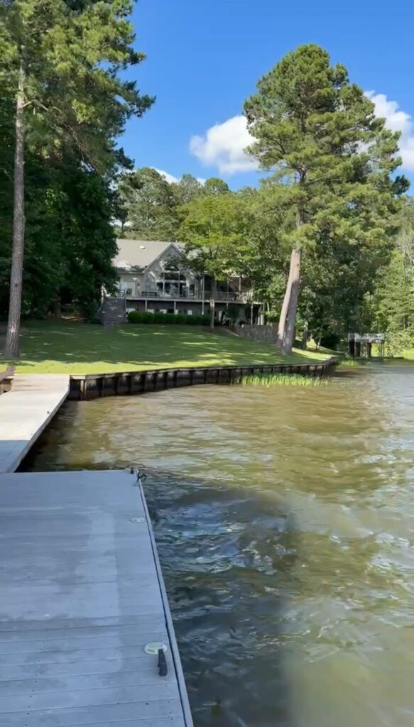 A view of a large lake house from the walk-out deck