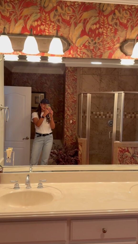 Julia taking a selfie picture in a bathroom mirror