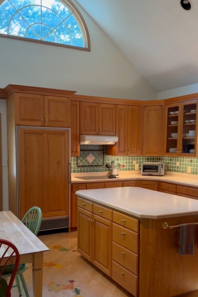 A kitchen with warm brown cabinets and white countertops