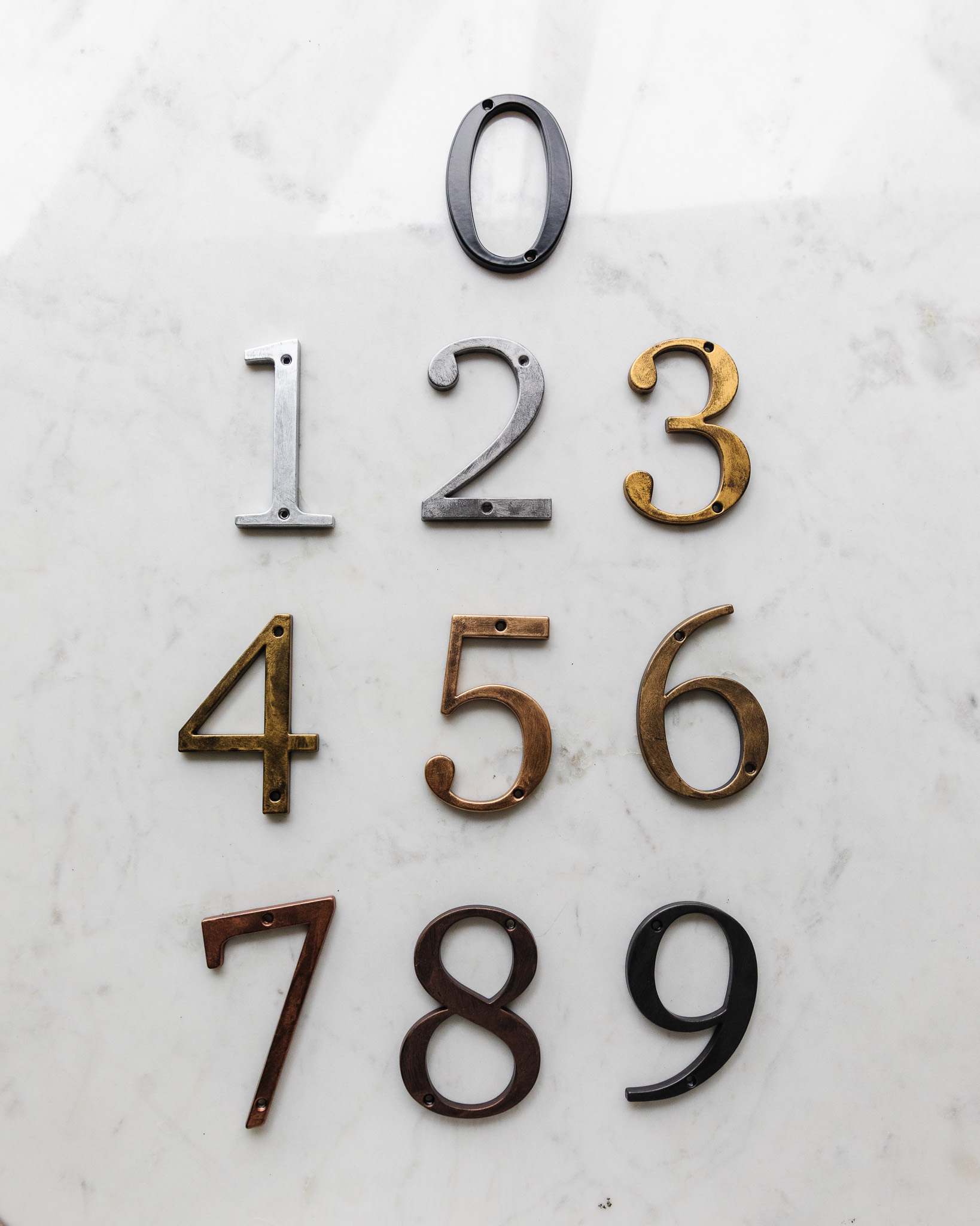 Comparison of all 9 Rub 'n Buff colors on black metal house numbers