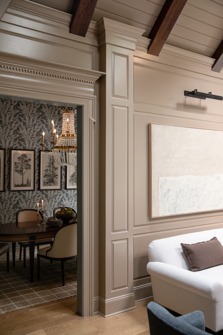 A view of the living room's wood-toned ceiling beams looking into the dining room
