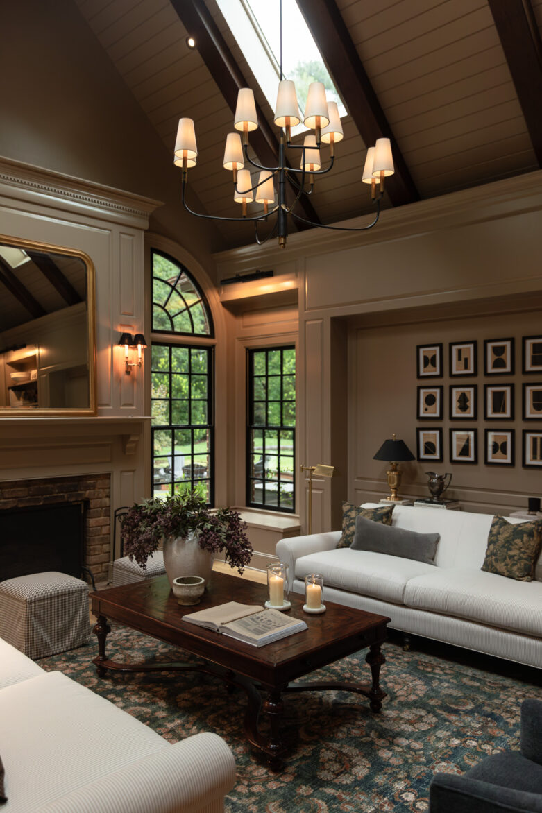 View of the skylights, ceiling planks, and wood-stained beams in a vaulted living painted moody milk chocolate brown