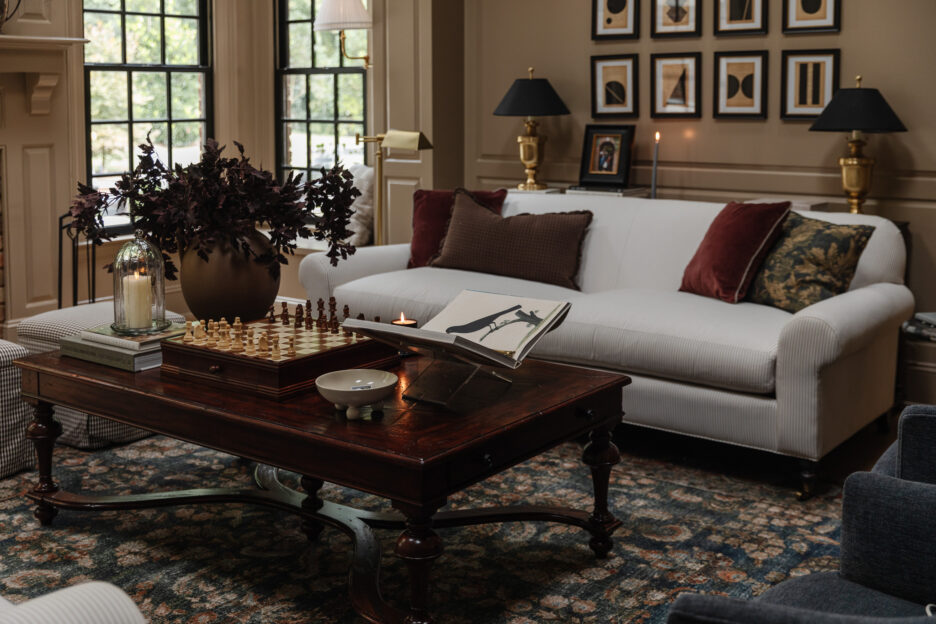 Moody modern traditional living room with pinstripe white and brown sofas and dark brown pillows