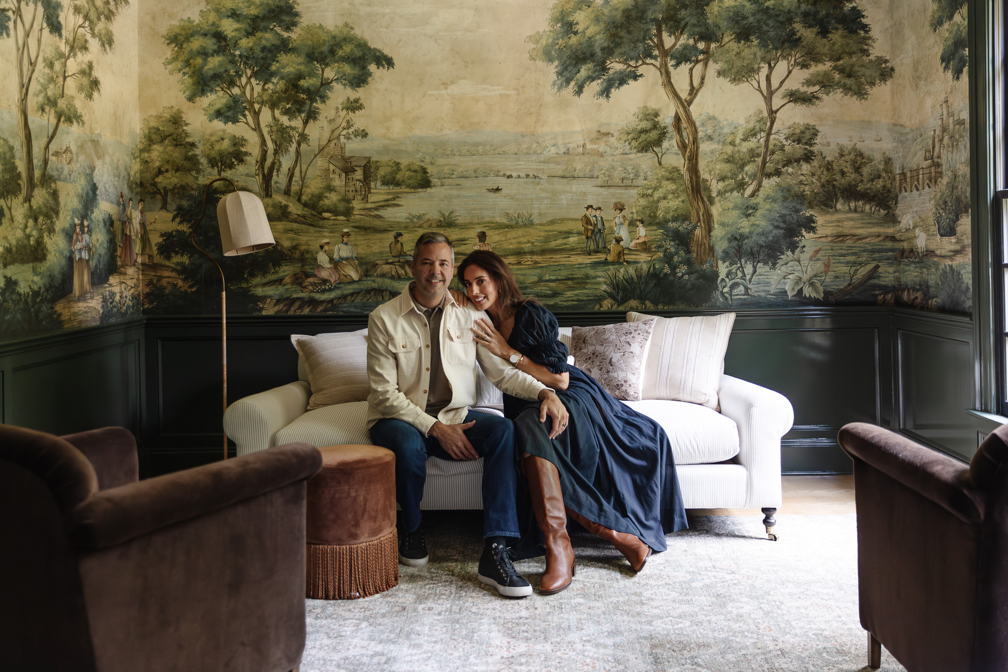 Chris & Julia sitting in the study on a white couch with a neutral bright Palma rug in front of them