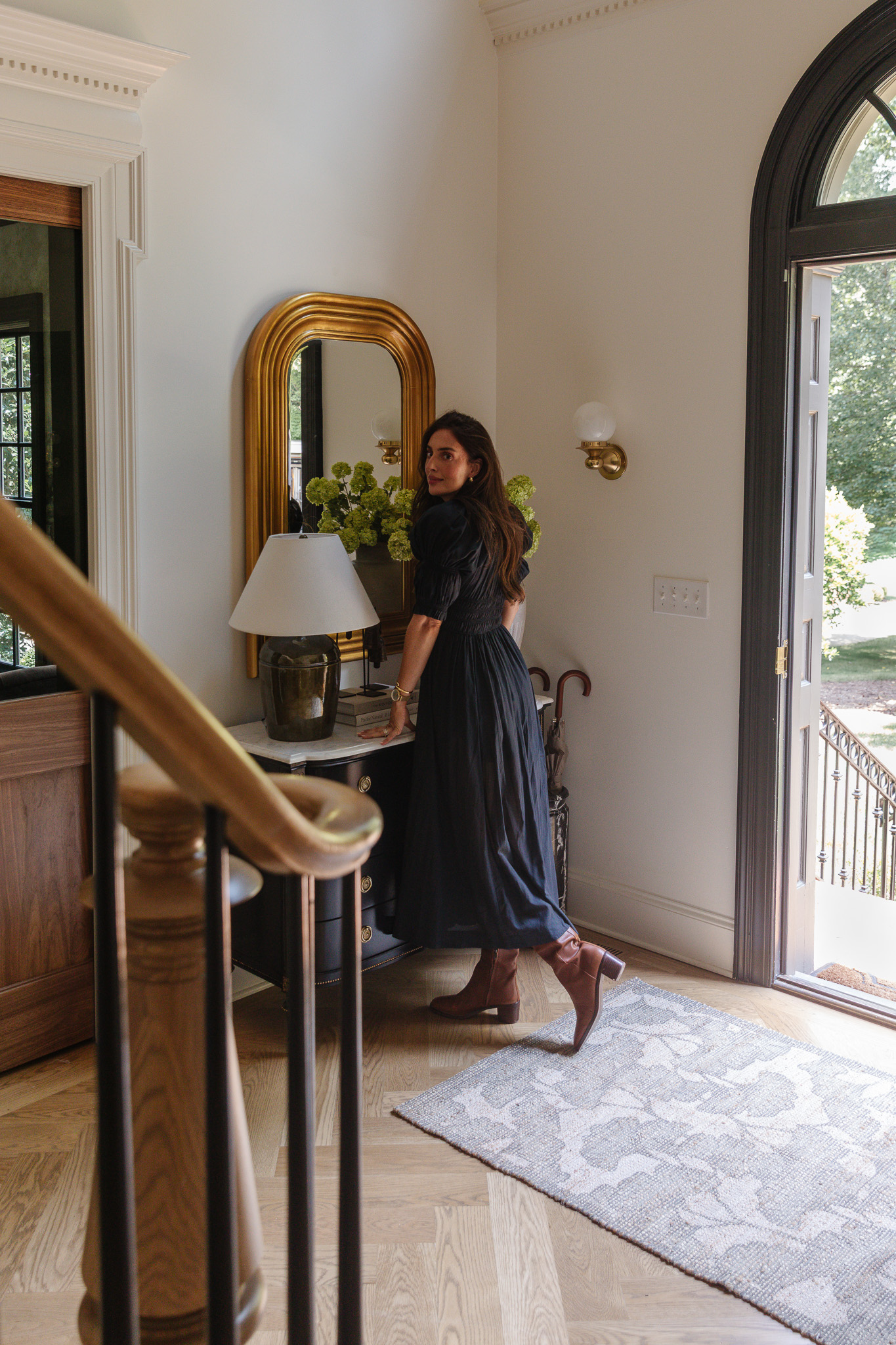 Julia standing in the entryway on a CLJ x Loloi Rue rug looking back over her shoulder