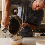 Chris pouring the chicken bone broth into a storage container