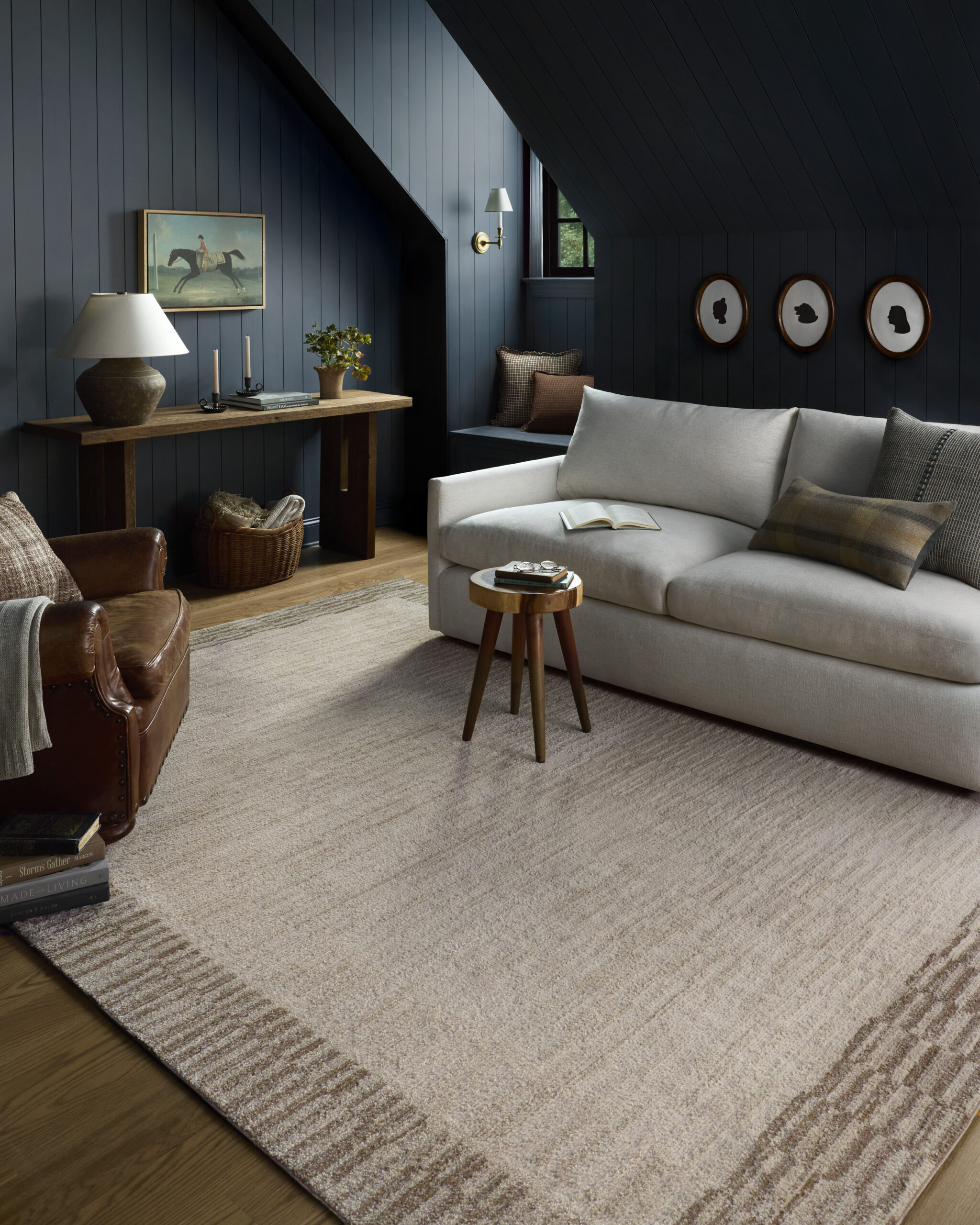 The Chris Loves Julia x Loloi Calvin neutral rug with a dark brown geometric border in a blue bonus room