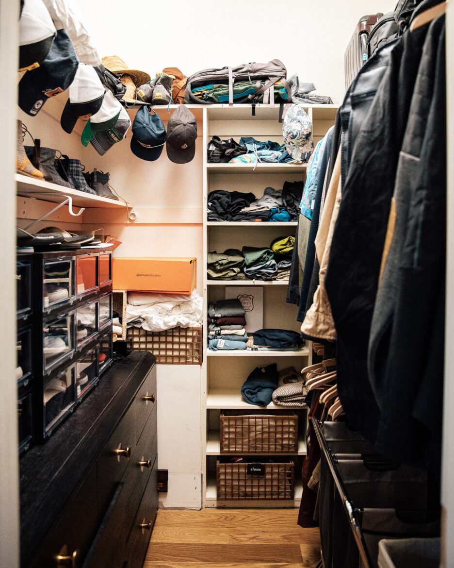 Cluttered closet with hats, hats, and folded clothes, organized with shelves and storage bins, from Chris Loves Julia home decor and organization tips.