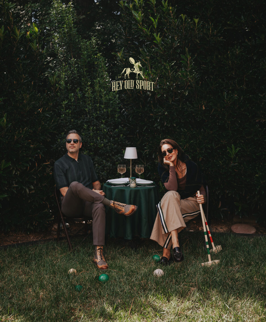 Classic outdoor garden dining setup with couple relaxing, lush greenery, stylish casual attire, and vintage accessories for home decor inspiration.