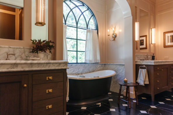 Moody, modern, traditional primary bathroom with dark tiles and warm beige pink walls