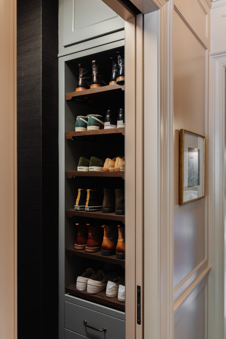 Black and brown shoe cabinet with multiple shelves for organized shoe storage in a stylish home entryway.