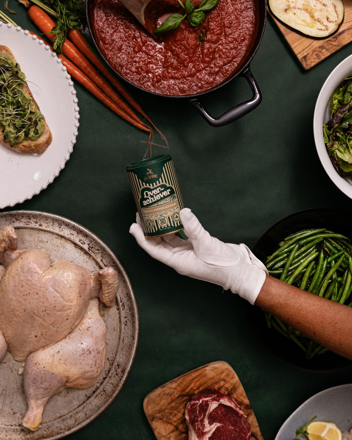 Savory meal ingredients with canned seasoning, fresh vegetables, raw chicken, and beef on a green table, food styling for home cooking recipes