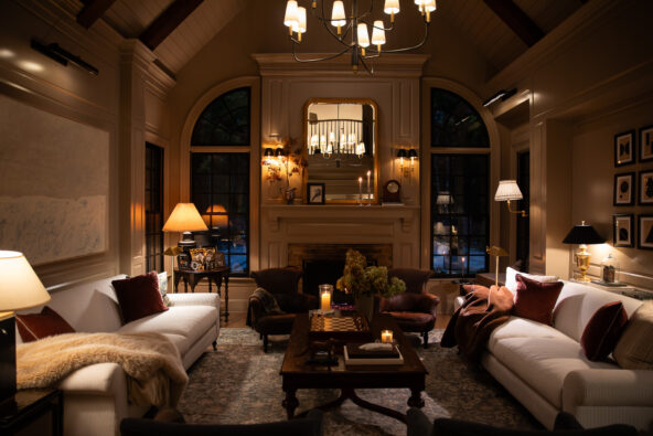 Elegant vintage living room with cozy sofas, warm lighting, and fireplace, showcasing classic interior design and stylish decor.