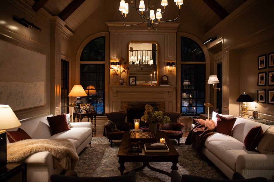 Elegant vintage living room with cozy sofas, warm lighting, and fireplace, showcasing classic interior design and stylish decor.