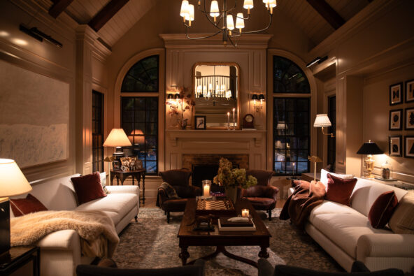 Cozy elegant living room with warm lighting, vintage-style furniture, and a brick fireplace, showcasing interior design inspiration from Chris Loves Julia.