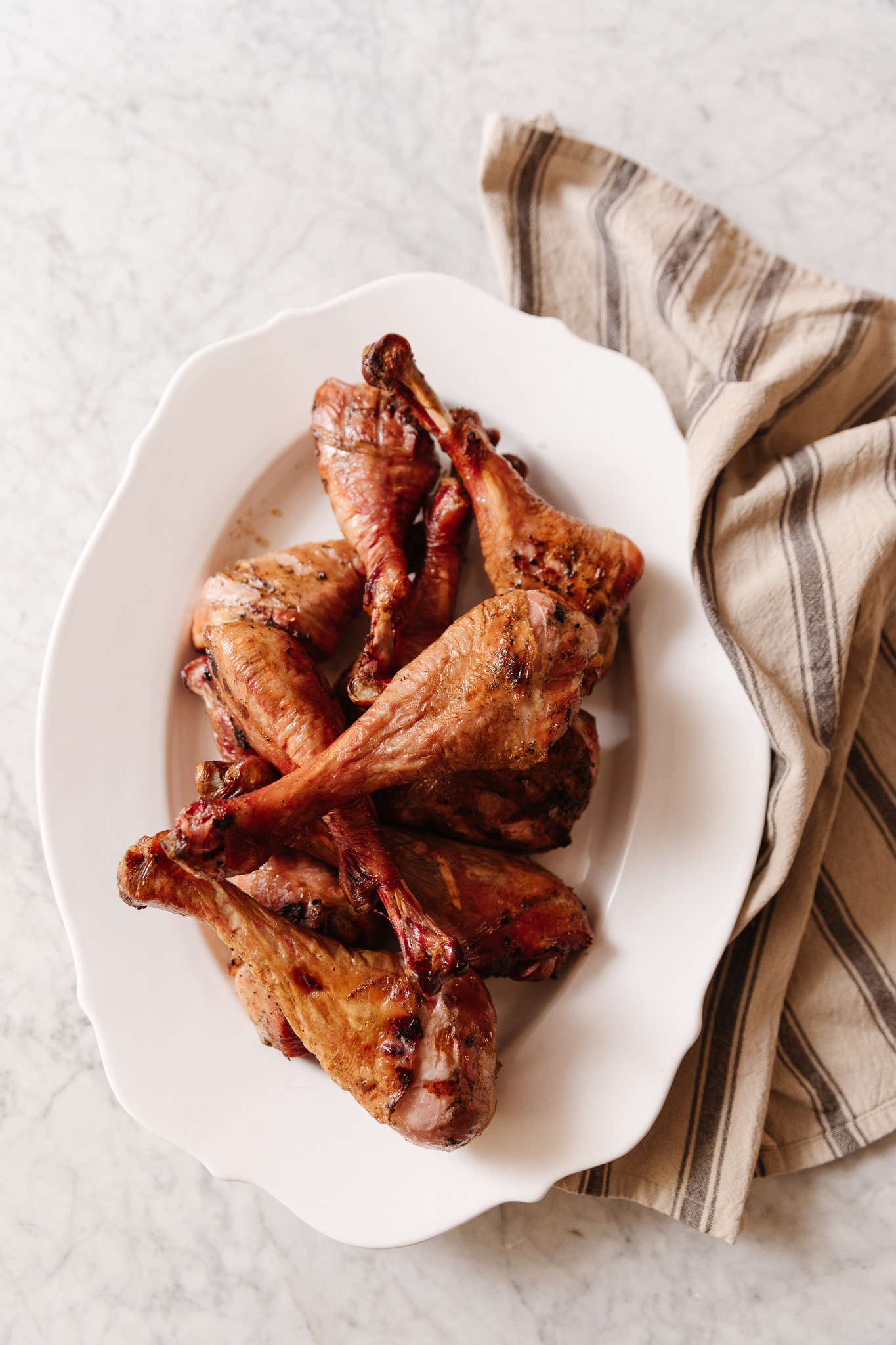 Smoked turkey wings on a white platter, perfect for family dinners or gatherings.