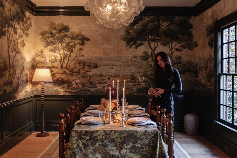 Elegant dining room with a vintage mural, dark green wall paneling, and a chandelier, creating a cozy, sophisticated atmosphere for hosting dinner parties.