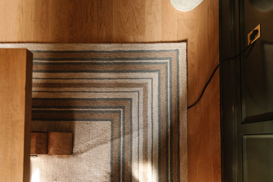 Feeding a cord under a rug up to a desk