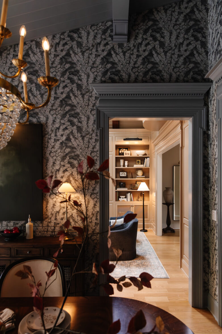 Cozy living room with built-in shelving and elegant decor, stylish wallpaper, warm lighting, and comfortable seating, showcasing home renovation and interior design by Chris Loves Julia.