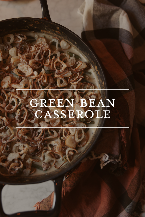 Crispy fried onions on green bean casserole in a baking dish, close-up of a classic holiday side dish topped with crispy onions, part of festive meal preparations, warm and cozy home cooking scene.