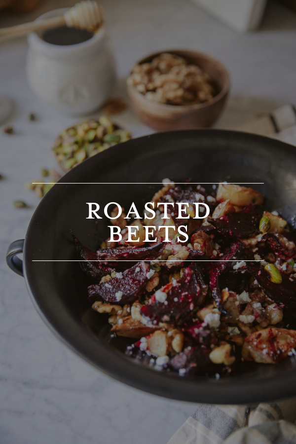 Roasted beets served in a black bowl with walnuts and feta cheese, on a marble surface, with honey and pistachios in the background, perfect for healthy, gourmet beet recipes.