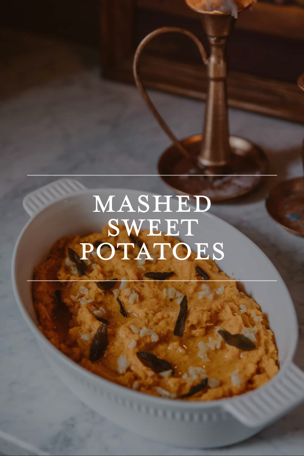 Mashed sweet potatoes in a white oval dish, garnished with herbs and served as a delicious side dish for holiday meals.