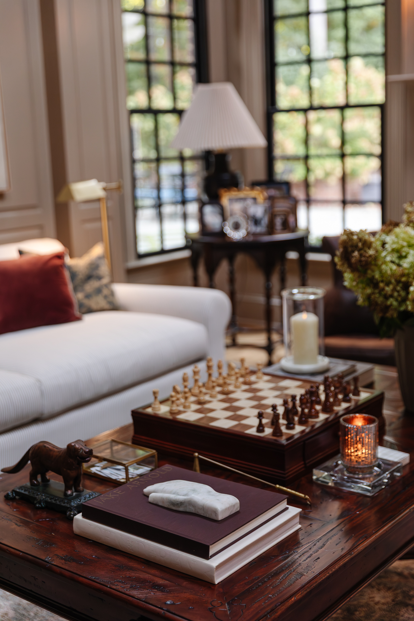 Chess set and home decor on a wooden coffee table in cozy home interior - Chris Loves Julia.