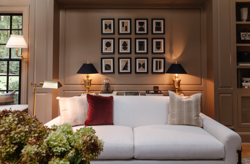Elegant living room with neutral tones, black and gold accents, and stylish artwork, creating a cozy yet sophisticated space for relaxation and hosting guests.