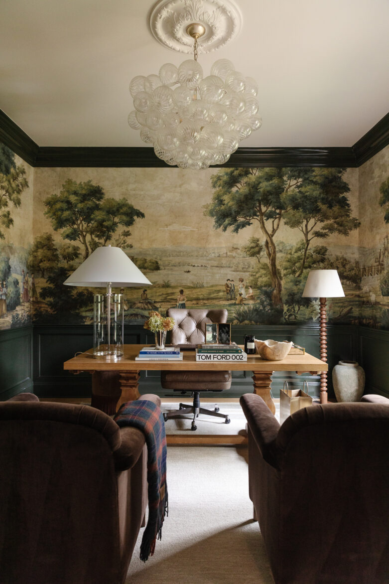Vintage-inspired home office with classic wallpaper mural, wooden desk, and cozy armchairs, showcasing elegant decor and task lighting.