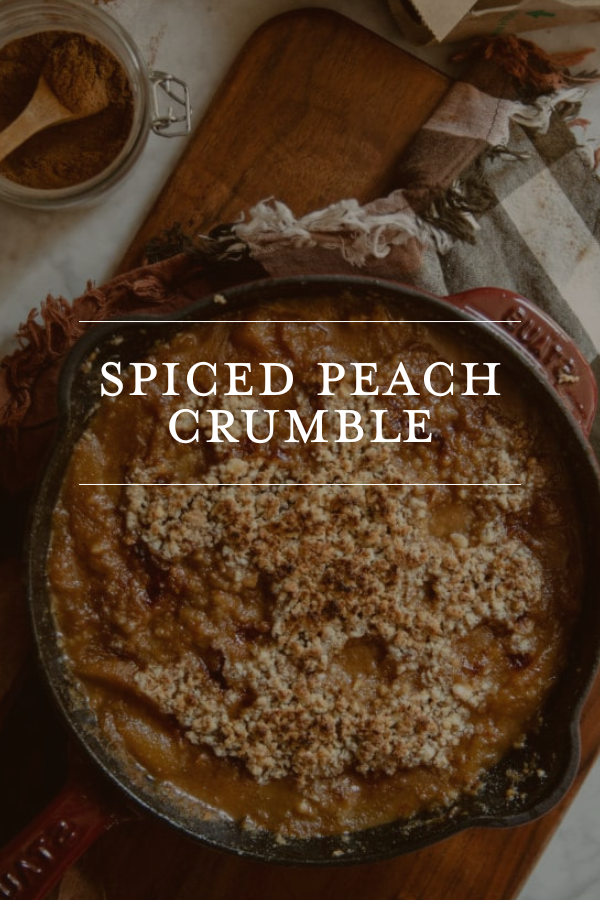 Spiced Peach Crumble baking dish with a crumbly topping, surrounded by cozy kitchen essentials for perfect autumn desserts.