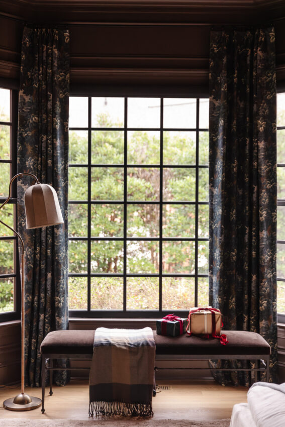 Elegant window seat with floral drapes and a cushioned bench, perfect for reading and relaxing in a stylish home interior.