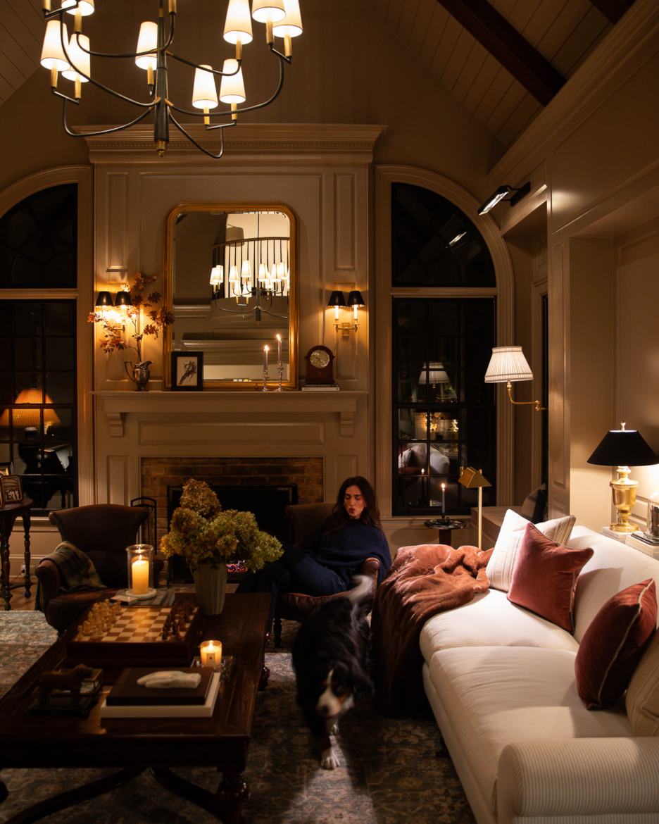 Julia lounging in her dark, moody, cozy living room with her Burmese Mountain Dog