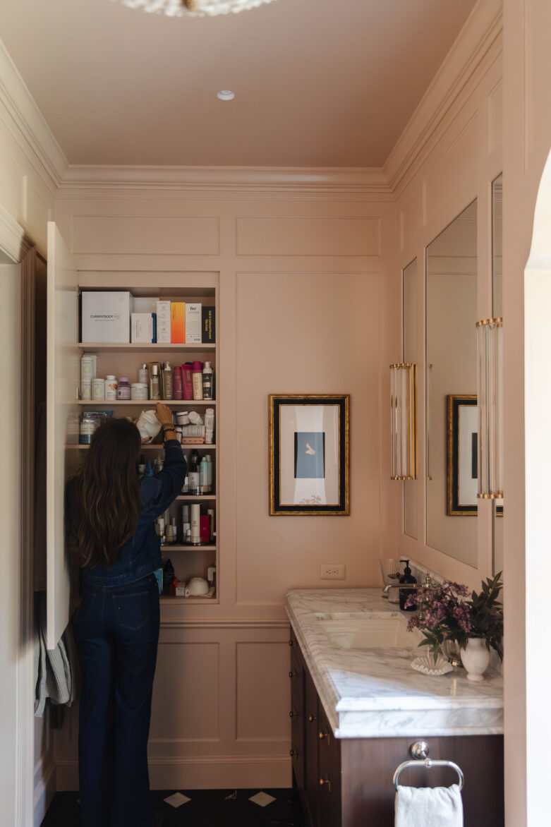 Julia opening a cabinet with products in her primary bathroom